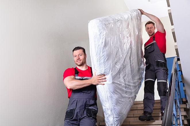 bedroom clutter being cleared as workers remove box spring in Bath OH